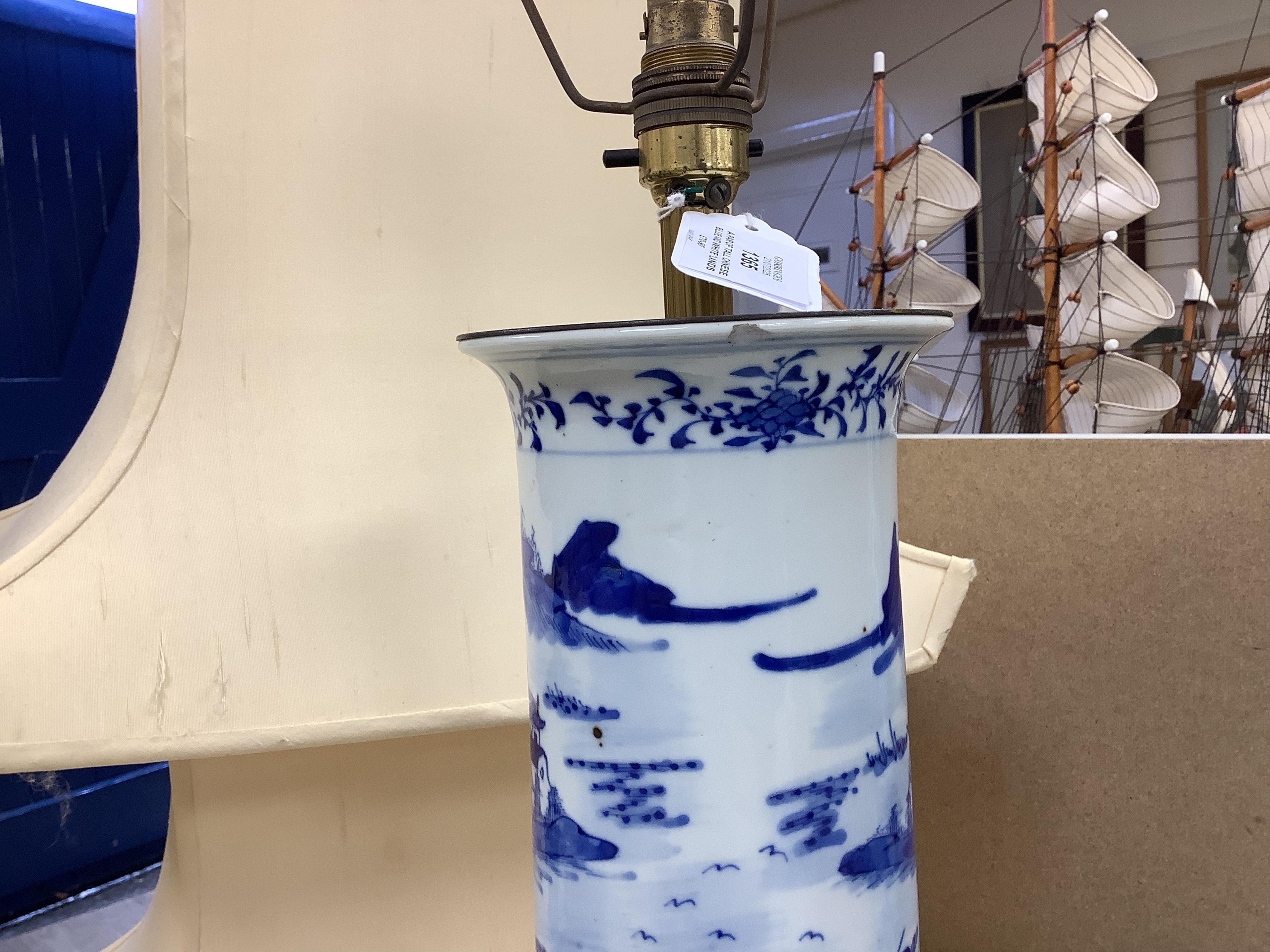A pair of tall Chinese blue and white ‘landscape’ sleeve vases, c.1900, drilled and mounted as lamps with shades, 39cm high excluding the fitting